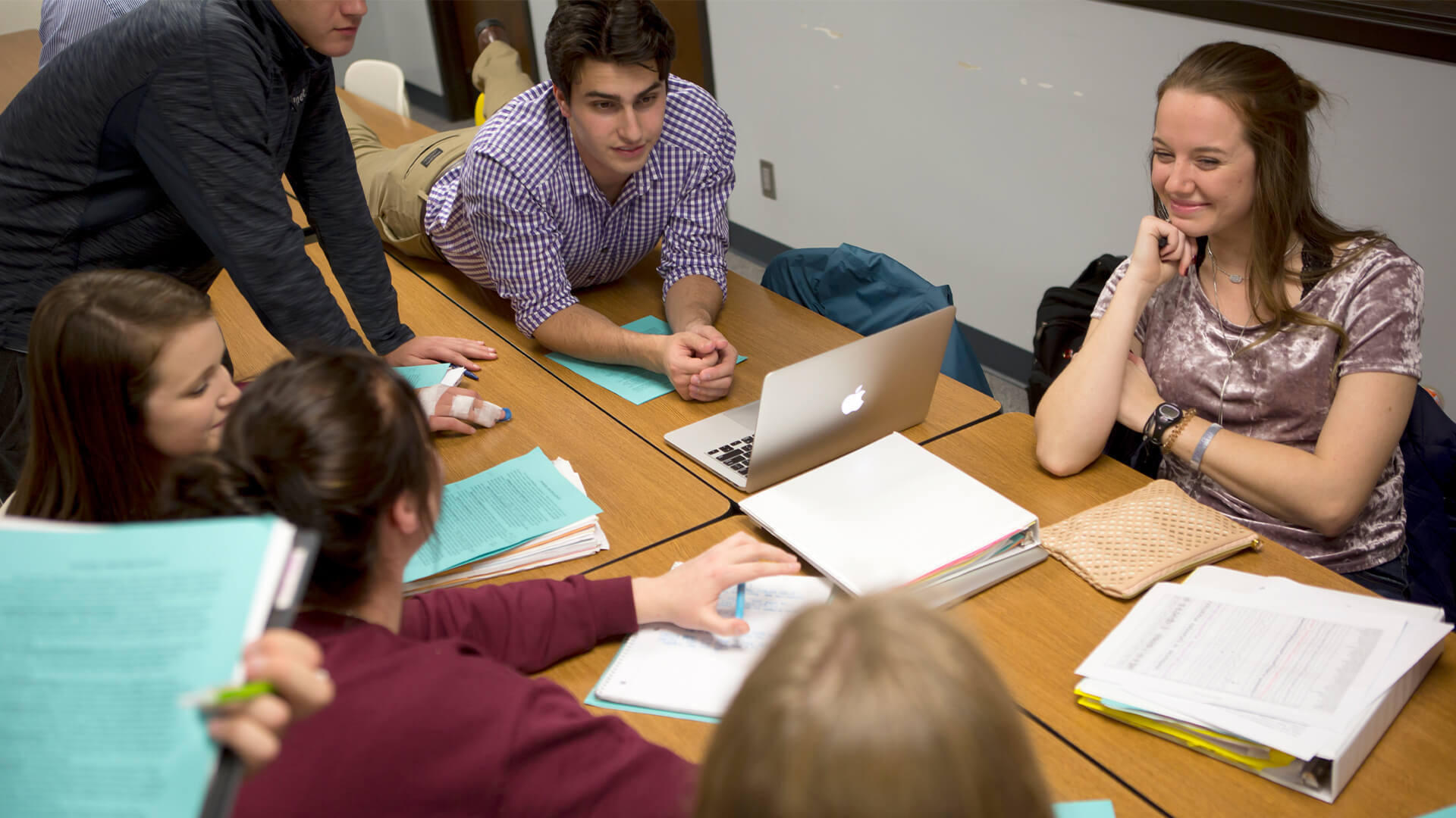 Students with laptops on table working on group project